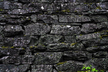 Medieval stone wall and arch architecture made from rough granite rocks. Close up.
