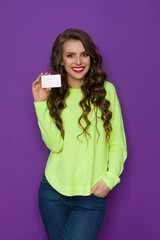 Fototapeta premium Beautiful Smiling Woman In Neon Green Sweater Is Holding White Card