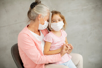 Grandmother and granddaughter wearing a respiratory masks