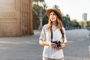 Young woman solo traveler enjoying a holiday in Barcelona taking pictures of the city. Female photographer with vintage camera photographing popular  tourist destination in Spain