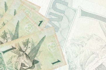1 Brazilian real bills lies in stack on background of big semi-transparent banknote. Abstract...