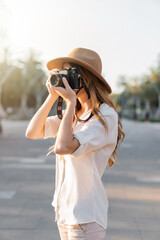Female professional photographer working in the streets of Barcelona with a vintage film camera....