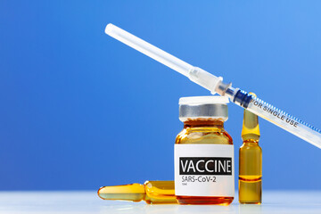 Sars-cov-2 vaccine vial and syringe on white table
