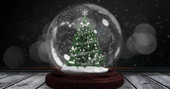 Digital animation of shooting star spinning around christmas tree in snow globe on wooden surface