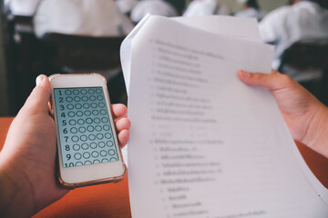 Exam by students doing educational test with using smartphone