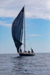 racing yacht with black spinnaker sailing in a regatta