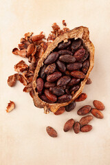 Fresh peeled cocoa beans in pod on beige background.