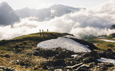 Tourists are standing on top of snowy hill admiring the stunning view