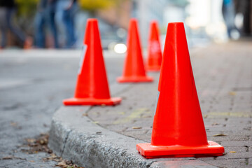 Orange movie shoot cones lining a city street curb to reserve a spot for production vehicles