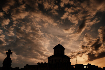 dark silhouette of a church against a cloudy sky