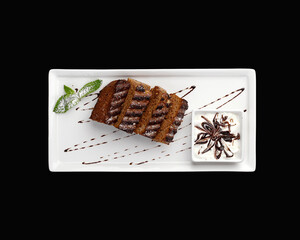 chocolate brownie on a white plate with sauce top view. High quality photo
