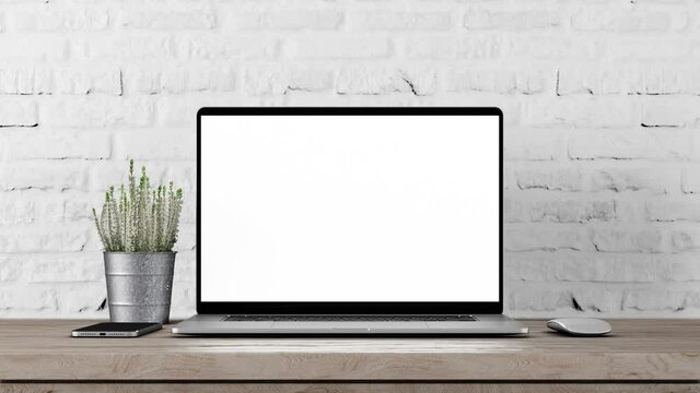 Laptop with blank screen on table smooth zoom in with mouse and smartphone. Loft or office white brick wall background, 4k 30fps UHD