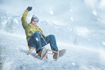 Happy man riding on a sled in winter - obrazy, fototapety, plakaty