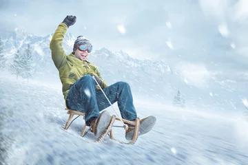 Fotobehang Happy man riding on a sled in winter © photoschmidt