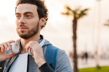 Focused unshaven guy with headphones looking aside