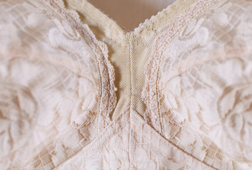 Fragment of women's old vintage lingerie close-up, pale pink background, selective focus