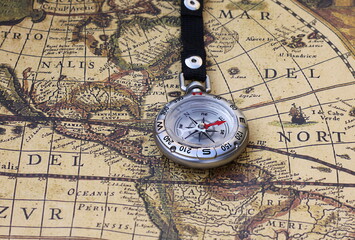 Classic round compass on background of old vintage map of world as symbol of tourism with compass, travel with compass and outdoor activities with compass