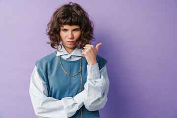 Displeased beautiful girl posing and pointing finger aside