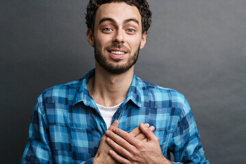 Happy caucasian guy posing with hand on his chest