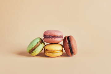 Tasty french macarons on a peach pastel background.