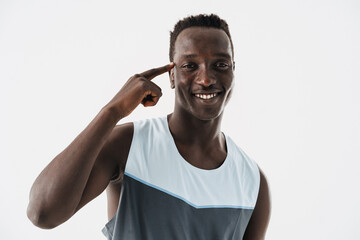 Smiling athletic african american sportsman pointing finger at his head