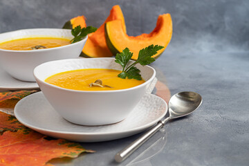 Fresh pumpkin cream soup with sour cream. Autumn lunch concept. A dietary, healthy dish.