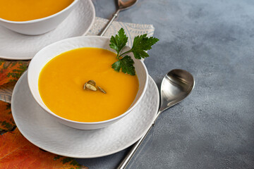 Fresh pumpkin cream soup with sour cream. Autumn lunch concept. A dietary, healthy dish.