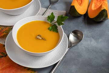 Fresh pumpkin cream soup with sour cream. Autumn lunch concept. A dietary, healthy dish.