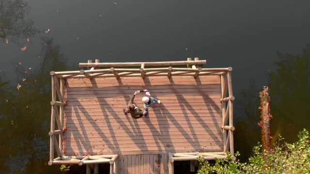 Couple dance in pier by Yedigoller lake, Bulo, Turkey. Aerial zoom out