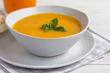 Fresh pumpkin cream soup with sour cream. Autumn lunch concept. A dietary, healthy dish.