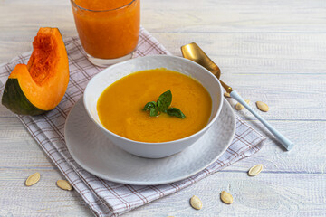 Fresh pumpkin cream soup with sour cream. Autumn lunch concept. A dietary, healthy dish.