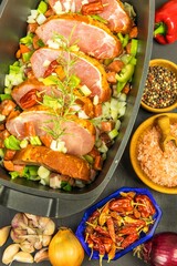 Raw pork chop in a baking dish with vegetables and sausage. Food and drink concept. Raw pork steak with chili ready for cooking dinner.