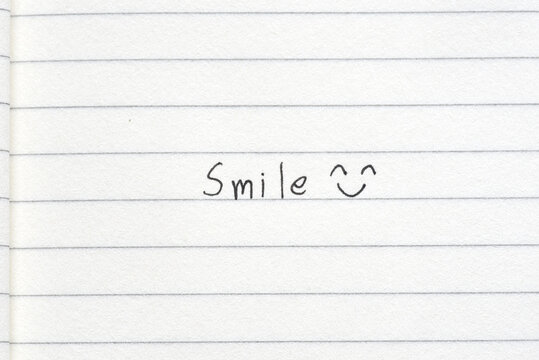 Wording Smile with smile symbol on white paper line