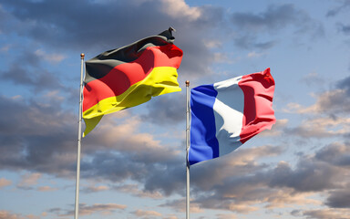 Beautiful national state flags of Germany and France together at the sky background. 3D artwork concept.