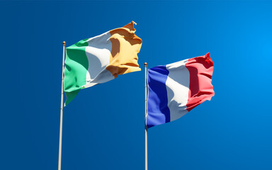 Beautiful national state flags of Ireland and France together at the sky background. 3D artwork concept.