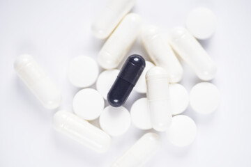 Carbon capsules suround by white medicine on white background