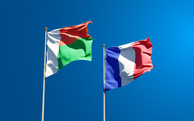 Beautiful national state flags of Madagascar and France together at the sky background. 3D artwork concept.