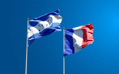 Beautiful national state flags of Honduras and France together at the sky background. 3D artwork concept.