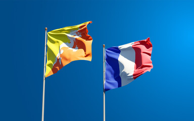 Beautiful national state flags of Bhutan and France together at the sky background. 3D artwork concept.