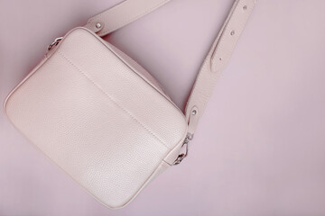 Female beige leather bag isolated on pink