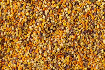 Organic bee pollen granules background top view