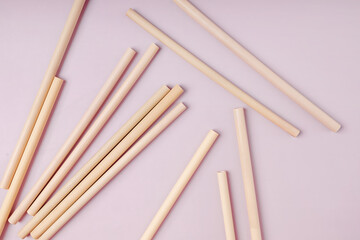 Bamboo straws straws on pink background.