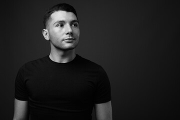 Portrait of young handsome man against gray background