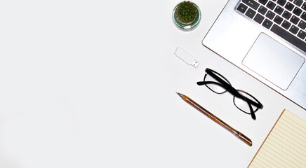 Workplace on a white table. Top view of a computer keyboard with office accessories. Business background concept.