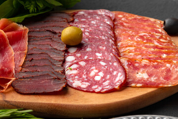 Wooden platter with meat cuts close up