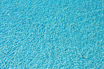 Surface of blue swimming pool,background of water in swimming pool. Ripple Water in swimming pool with sun reflection