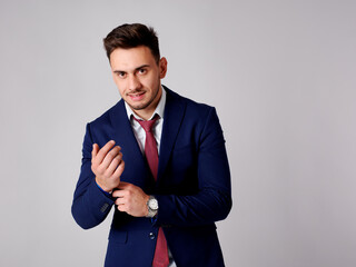 Young stylish man finishing buttoning up his sleeves