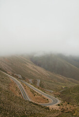 Road high in the mountains. View of the sinuous asphalt highway called Lipan Slope, across the Andes mountains under a cloudy sky.