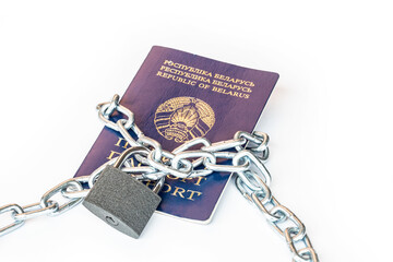 Studio lighting. the citizen's passport is tied with a metal chain in the center with a yellow lock. The concept of violation of the rights of citizens, a ban on movement