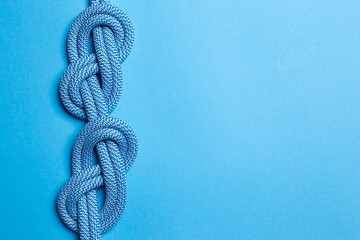 Eight knots on a rope on a blue background. Copy space.